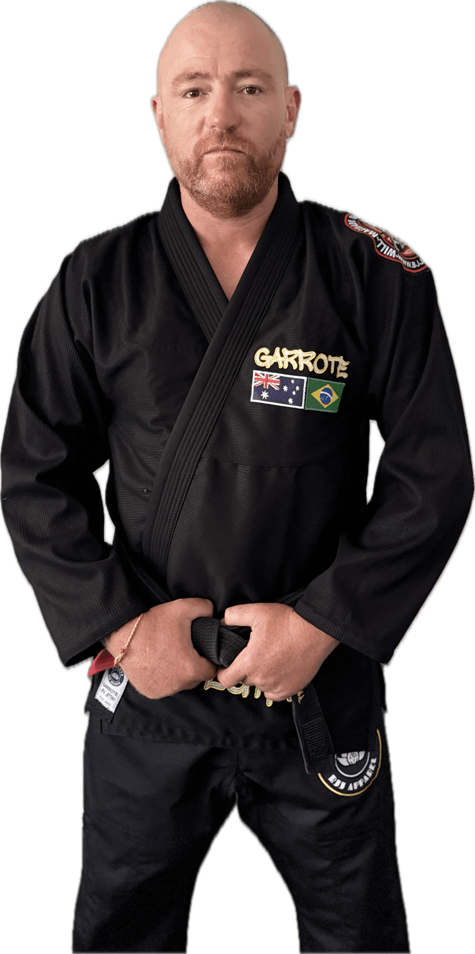 Person in a black martial arts gi with country flag patches, holding a black belt.